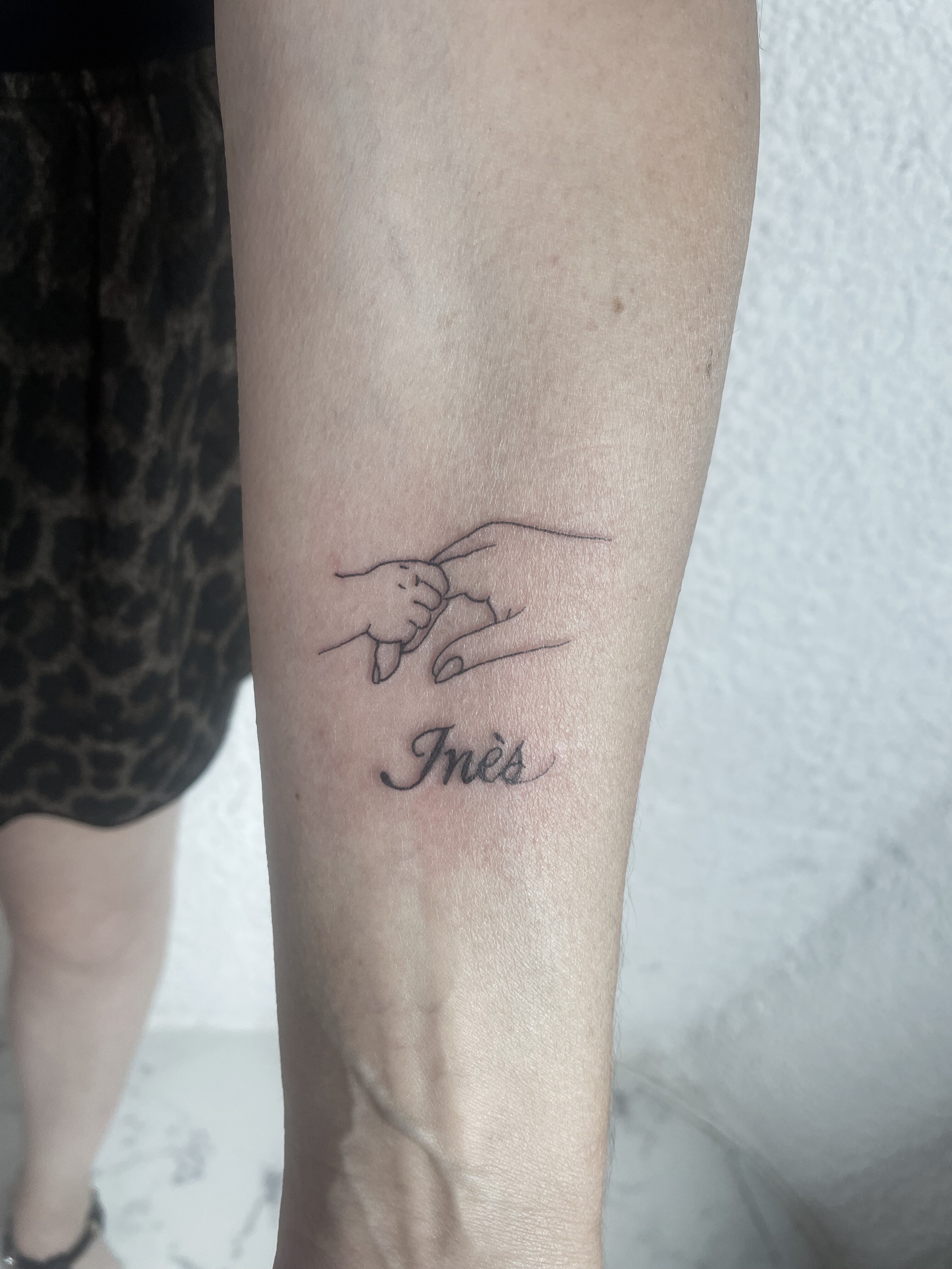 fine line baby hand holding finger tattoo with name